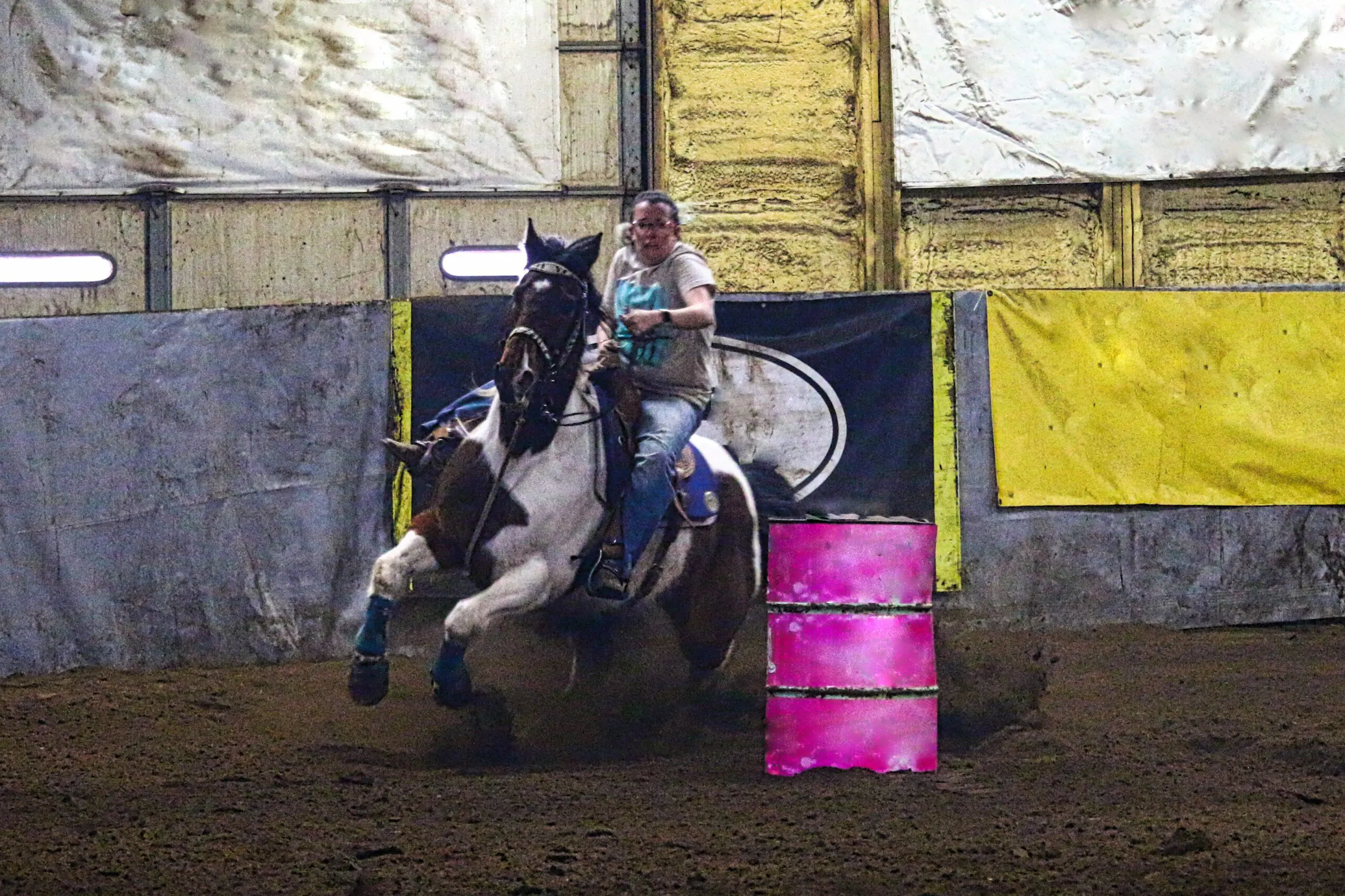 Horse and rider barrel racing indoors